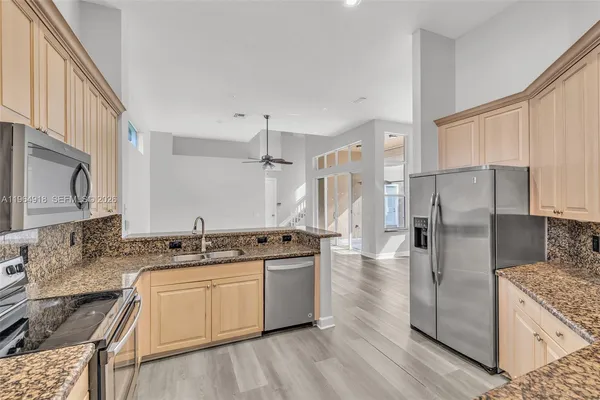 a kitchen with stainless steel appliances granite countertop a sink stove and refrigerator