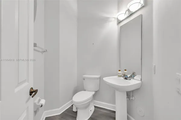a bathroom with a sink toilet and a mirror