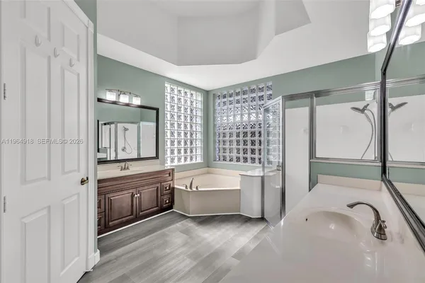 a spacious bathroom with a tub sink and mirror