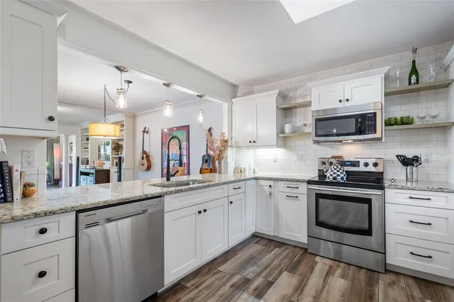 a kitchen with stainless steel appliances granite countertop a sink stove and cabinets
