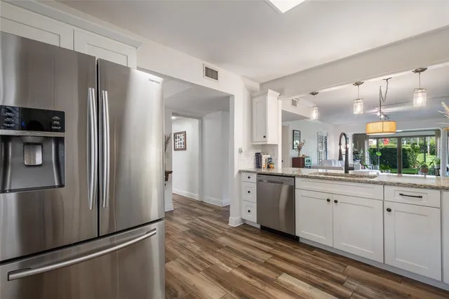 a bathroom with a granite countertop sink a mirror and shower