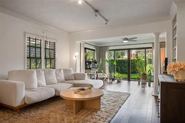 a living room with furniture and a large window with wooden floor