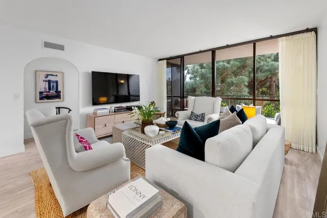 a living room with couches and a large mirror with wooden floor