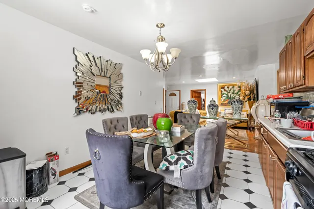 a view of a dining room with furniture a chandelier and wooden floor