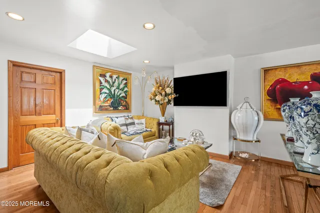 a living room with furniture a flat screen tv and a window