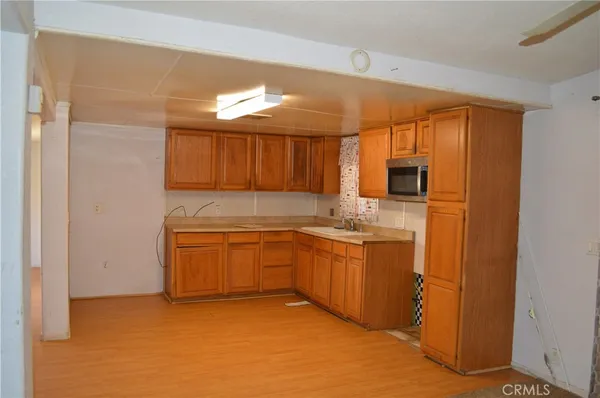 a kitchen with granite countertop a sink cabinets stainless steel appliances and a window
