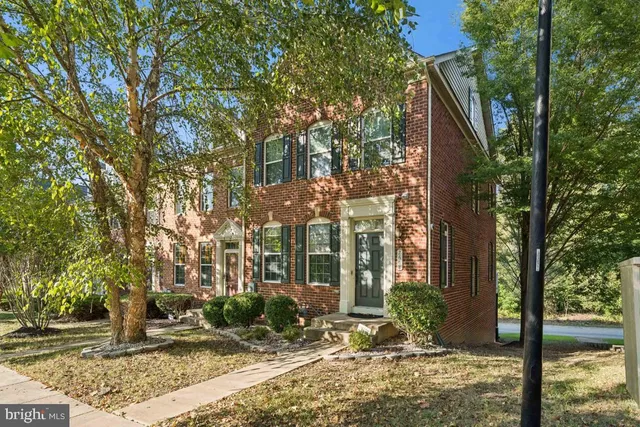 a view of a brick house with a large windows and large tree