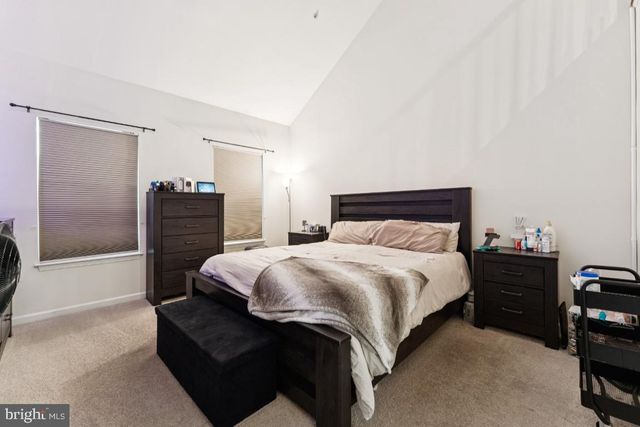 a bedroom with a bed and dresser with mirror