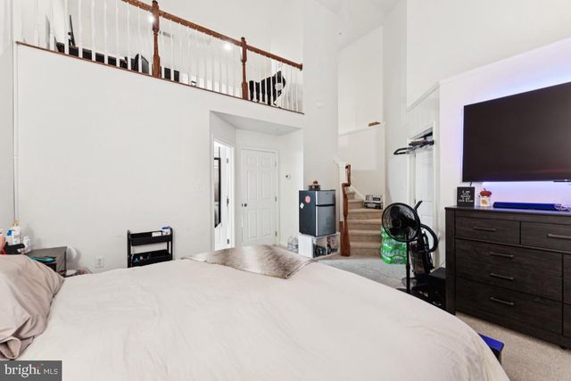 a bedroom with a bed and a flat tv screen on dresser