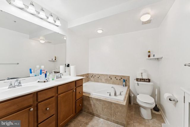 a bathroom with a toilet a sink a mirror and a bathtub