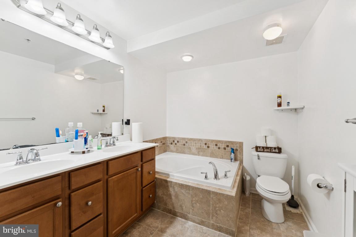 2608 St Marys View Road Accokeek, MD 20607 - Photo 16 of 26 a bathroom with a toilet a sink a mirror and a bathtub