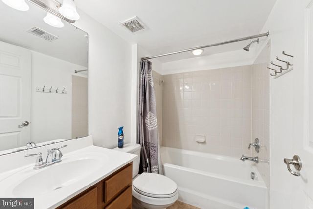 a bathroom with a sink a toilet a mirror a bathtub and shower