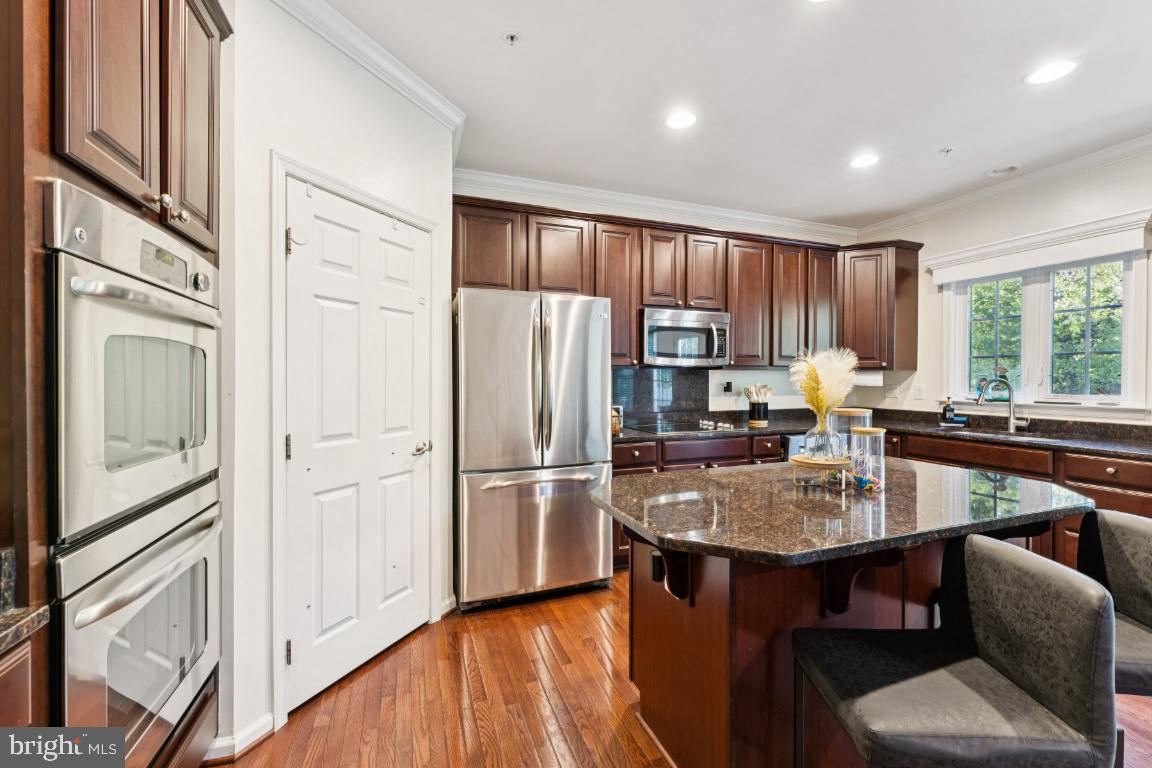 2608 St Marys View Road Accokeek, MD 20607 - Photo 6 of 25 a kitchen with a refrigerator a stove a sink dishwasher with a dining table and chairs with wooden floor