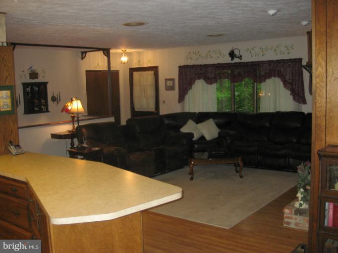1980 Plum Point Road Huntingtown, MD 20639 - Photo 5 of 27 a room with wooden floor and large windows