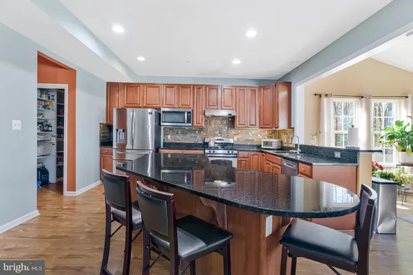 a kitchen with stainless steel appliances granite countertop a sink stove and cabinets