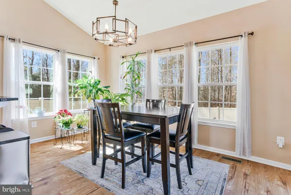 a living room with furniture kitchen view and a chandelier