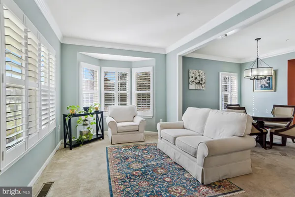 a dining room with wooden floor a chandelier a wooden table and chairs