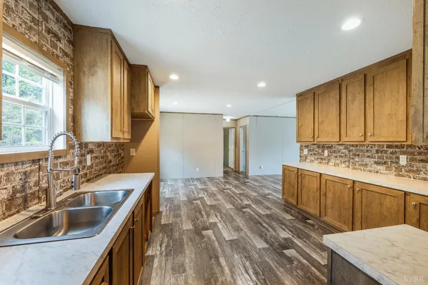 a kitchen with kitchen island granite countertop a sink and refrigerator