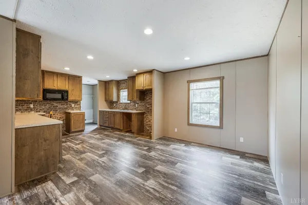 a view of kitchen with microwave stove refrigerator and cabinets