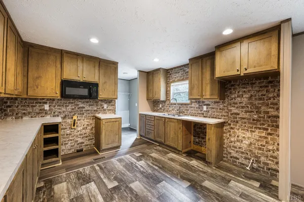 a kitchen with stainless steel appliances a stove sink microwave and cabinets