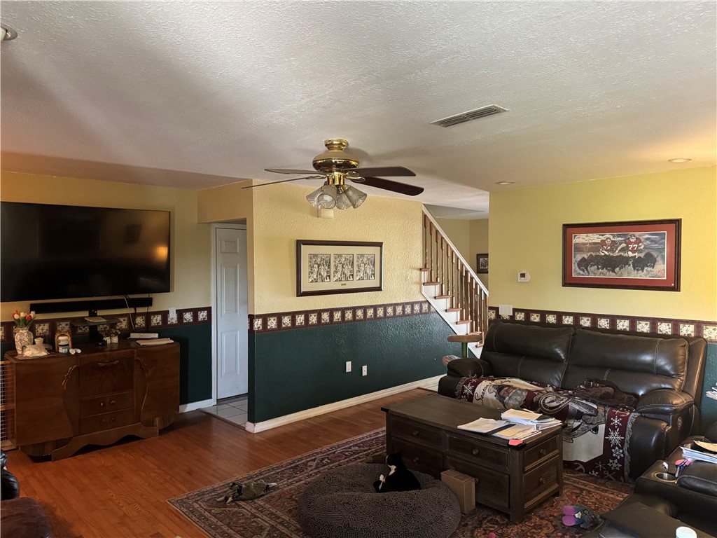 1035 Hatcher Road Springdale, AR 72764 - Photo 5 of 10 Living room featuring wood finished floors, a textured ceiling, and ceiling fan