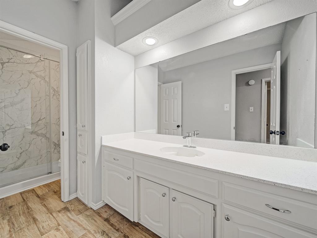 121 Northeast Brushy Mound Road Burleson, TX 76028 - Photo 28 of 35 a spacious bathroom with a shower sink and mirror