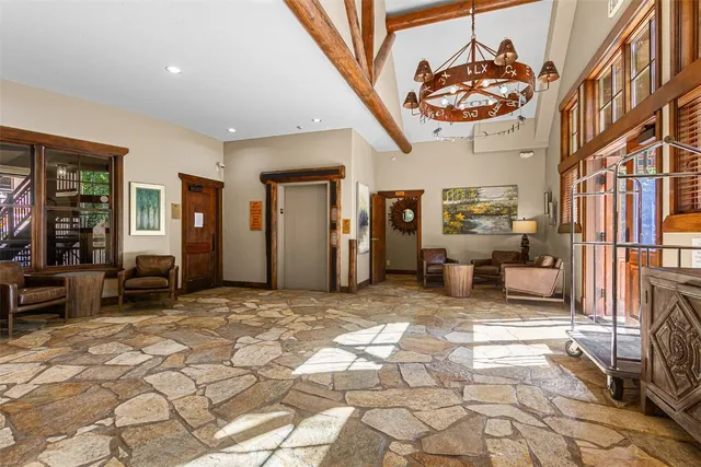 a living room with furniture and floor to ceiling windows