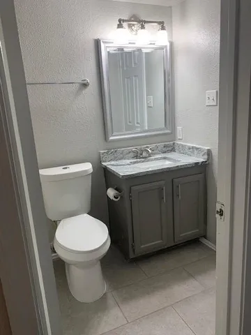 a bathroom with a toilet sink and mirror