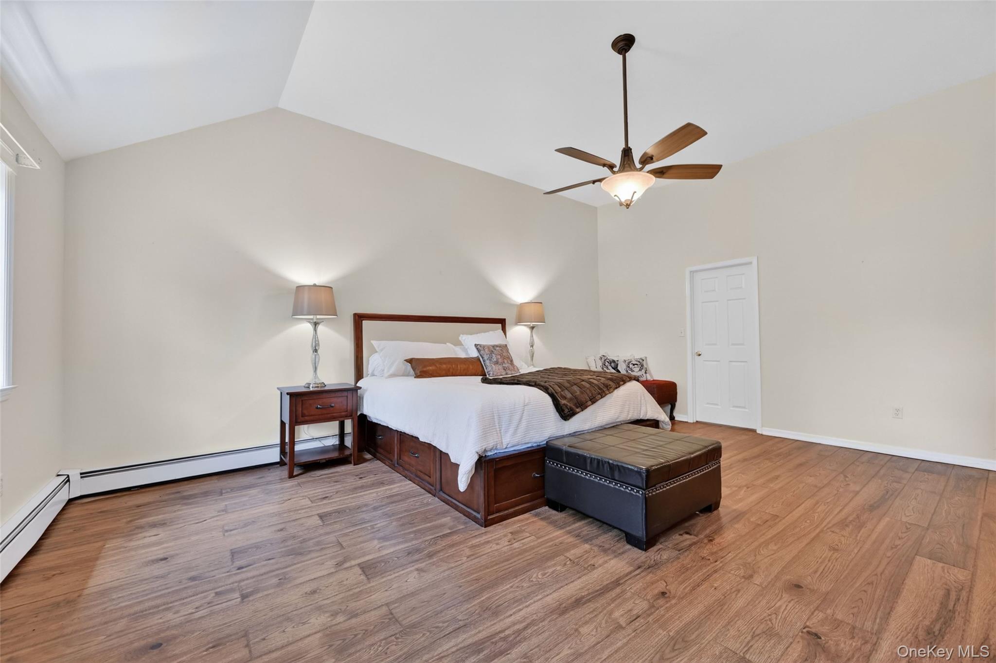 19 Bull Mine Road Chester, NY 10918 - Photo 22 of 42 Vaulted ceiling bedroom featuring wood-finish flooring, a ceiling fan with integrated lighting, and a white paneled door