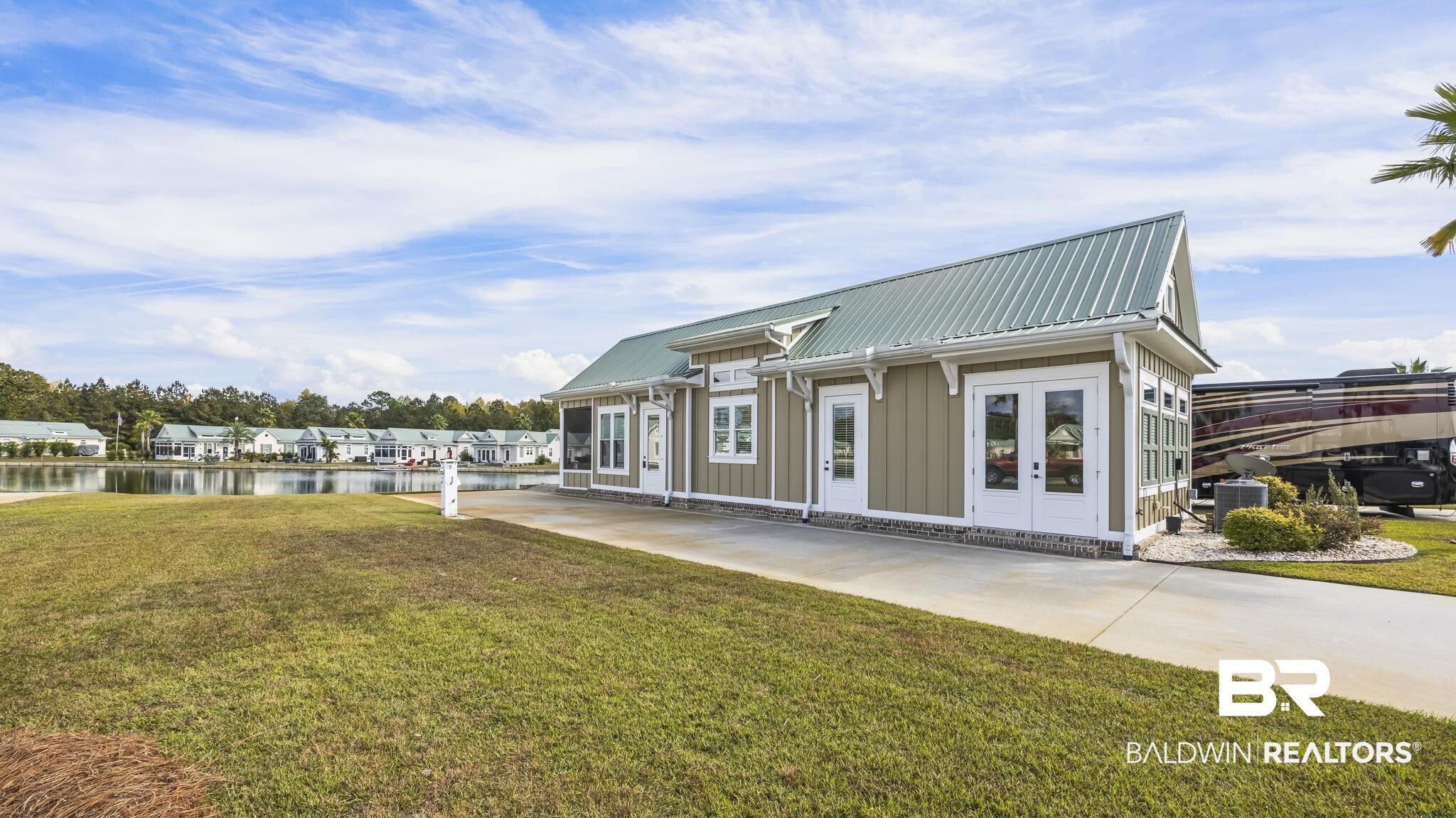 12004 Raptor Court Elberta, AL 36530 - Photo 4 of 57 Rear view of property with a lawn, a water view, board and batten siding, and a metal roof
