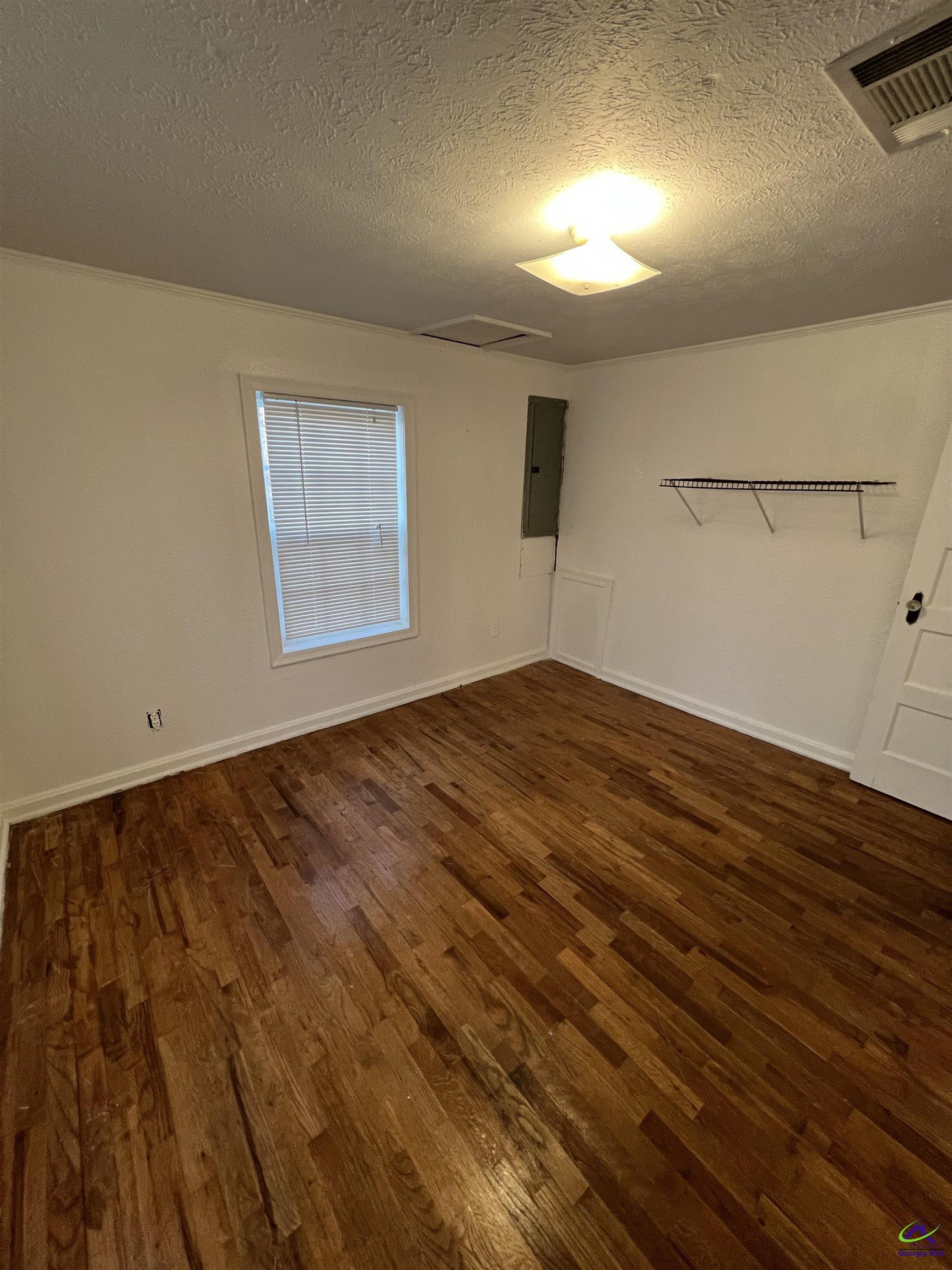 3281 State Rte 126 Dublin, GA 31021 - Photo 17 of 22 an empty room with wooden floor and windows