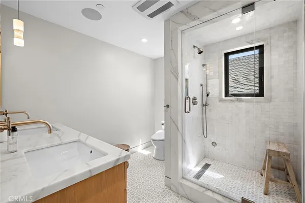 a bathroom with a sink a toilet and shower