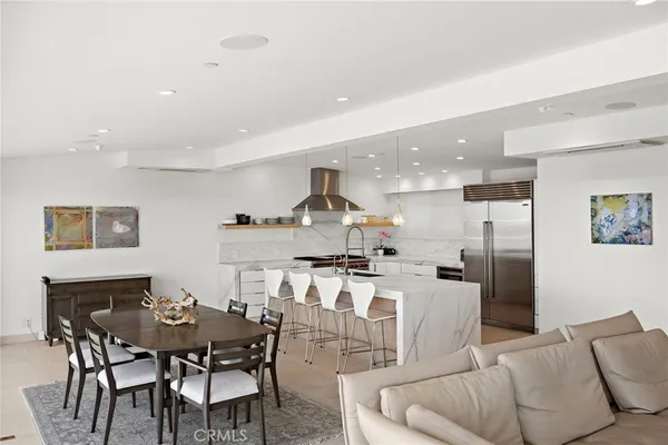 a living room with stainless steel appliances kitchen island granite countertop a dining table and chairs