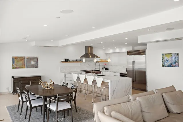 a living room with stainless steel appliances kitchen island granite countertop a dining table and chairs