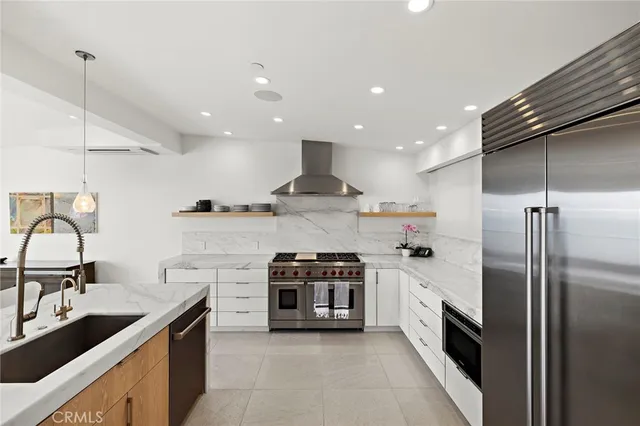 a kitchen with stainless steel appliances granite countertop a sink a stove and a refrigerator