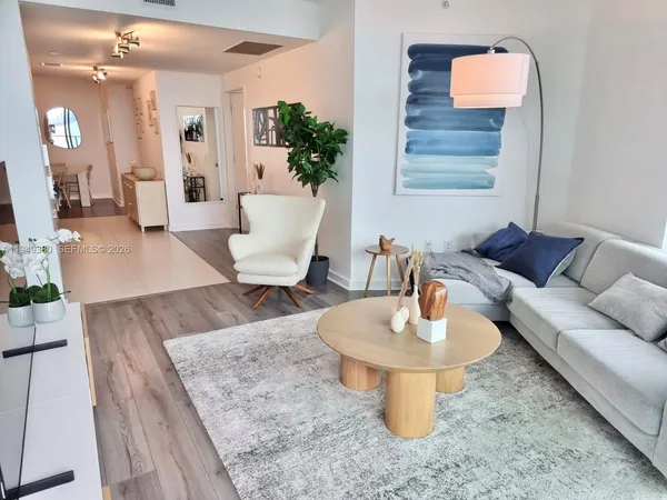 a living room with furniture and a wooden floor