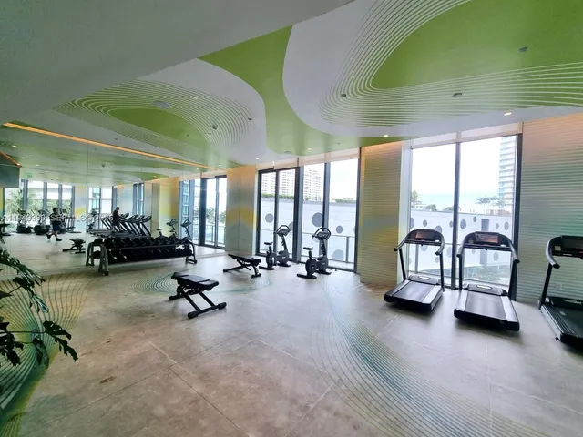 a living room with furniture gym equipment and a large window