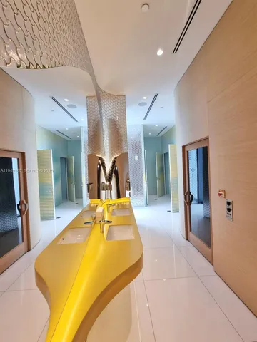 a bedroom with a bed and a large mirror on the dresser