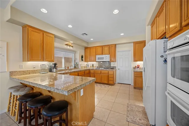 a kitchen with stainless steel appliances granite countertop a sink and a refrigerator