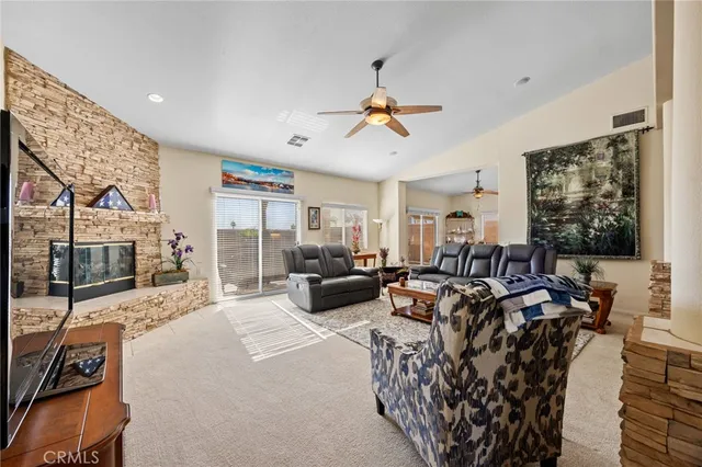 a living room with furniture a flat screen tv and a large window