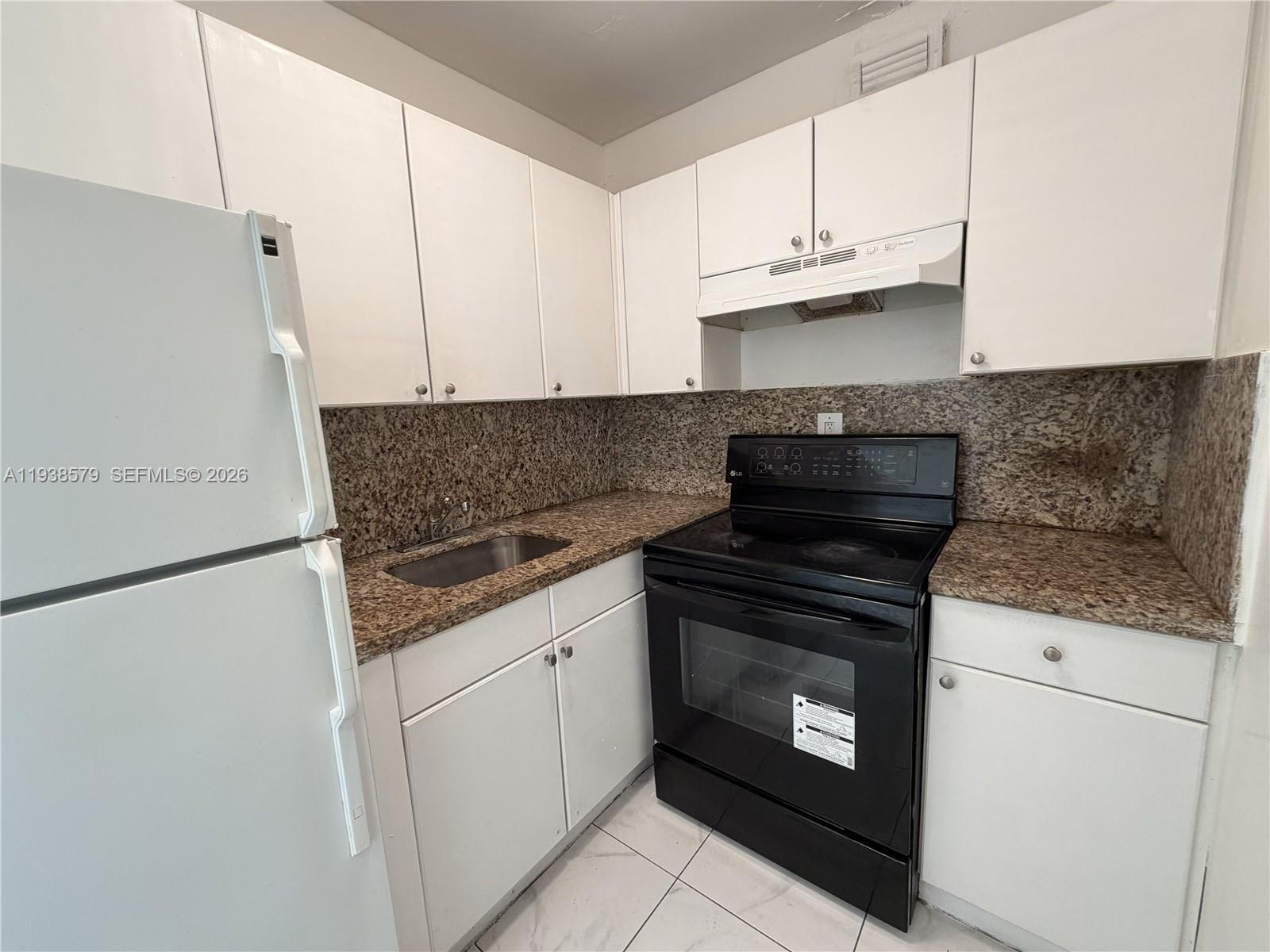 1860 Southwest 22nd Street, Unit 8 Miami, FL 33145 - Photo 2 of 10 a kitchen with granite countertop a stove sink and cabinets