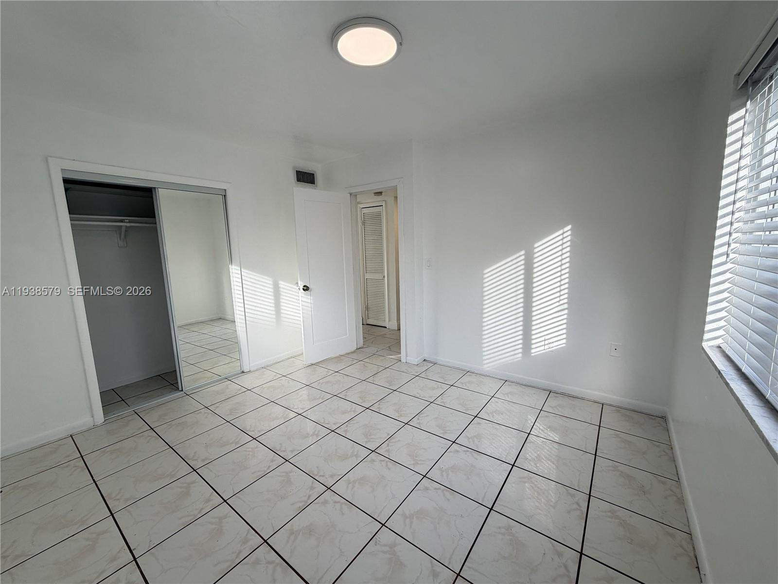 1860 Southwest 22nd Street, Unit 8 Miami, FL 33145 - Photo 6 of 10 an empty room with windows and closet