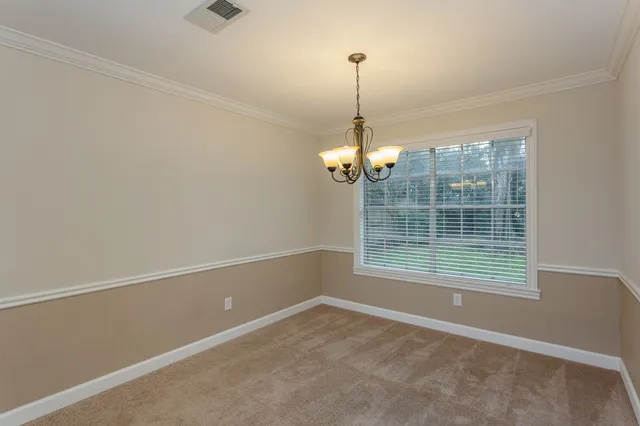 a view of a room with a chandelier fan and windows