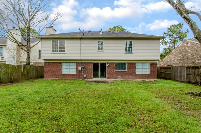 a view of a yard in front of a house with large tree