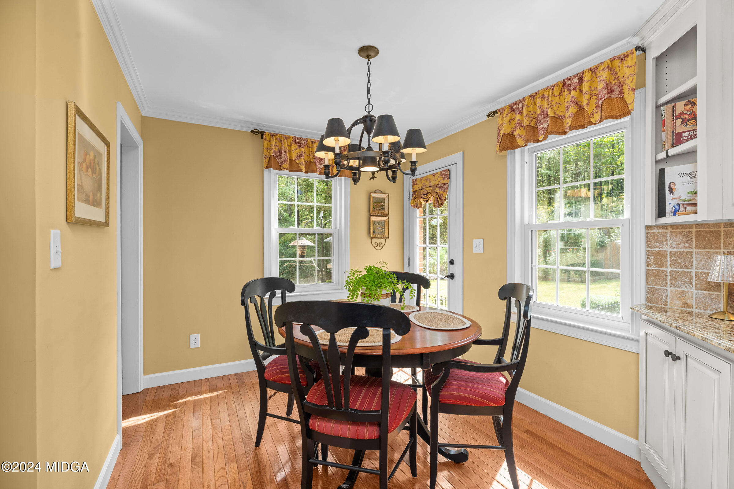 552 Plantation Road Gray, GA 31032 - Photo 16 of 38 a dining room with furniture a chandelier and wooden floor