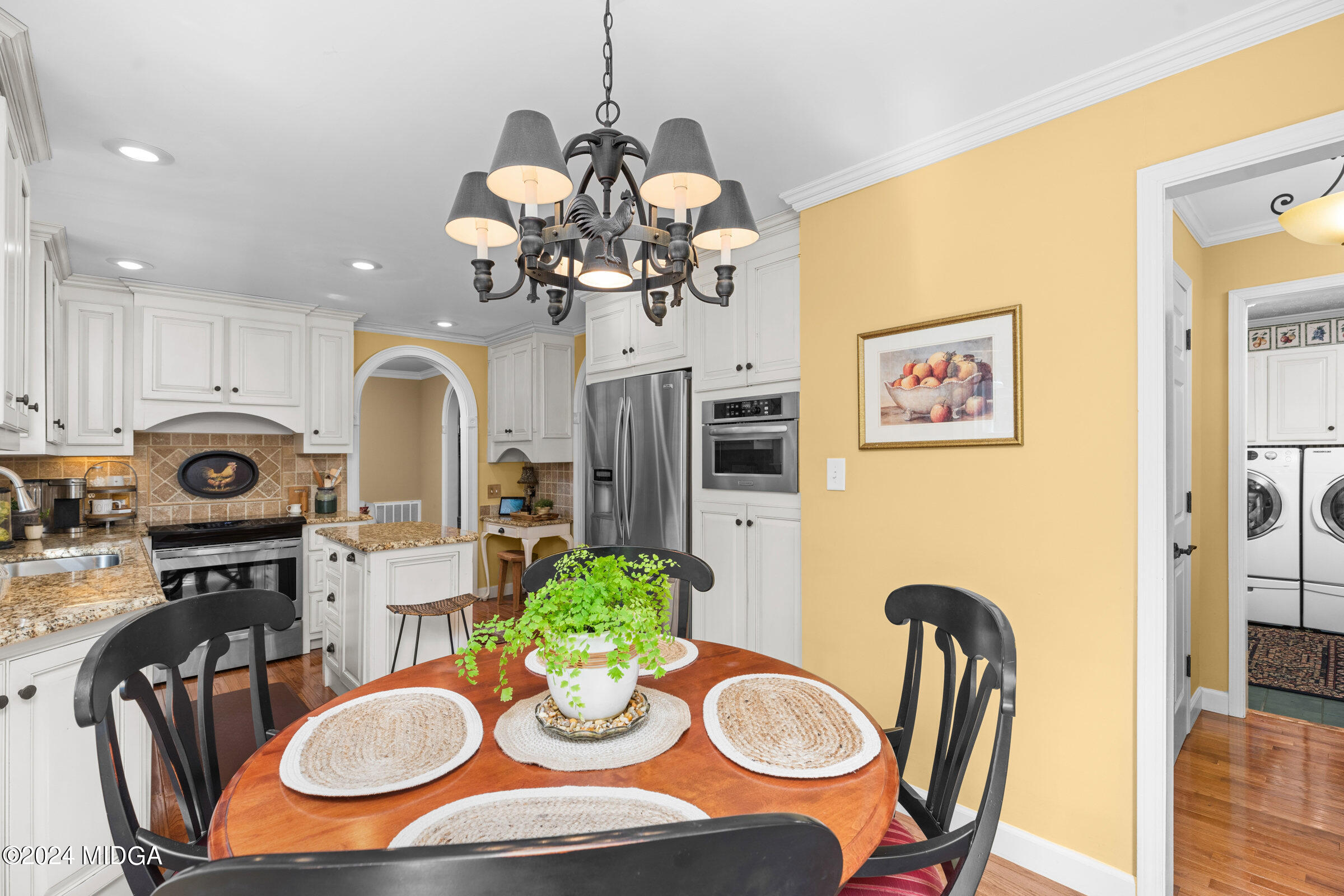 552 Plantation Road Gray, GA 31032 - Photo 17 of 38 a dining room filled chandelier and wooden floor