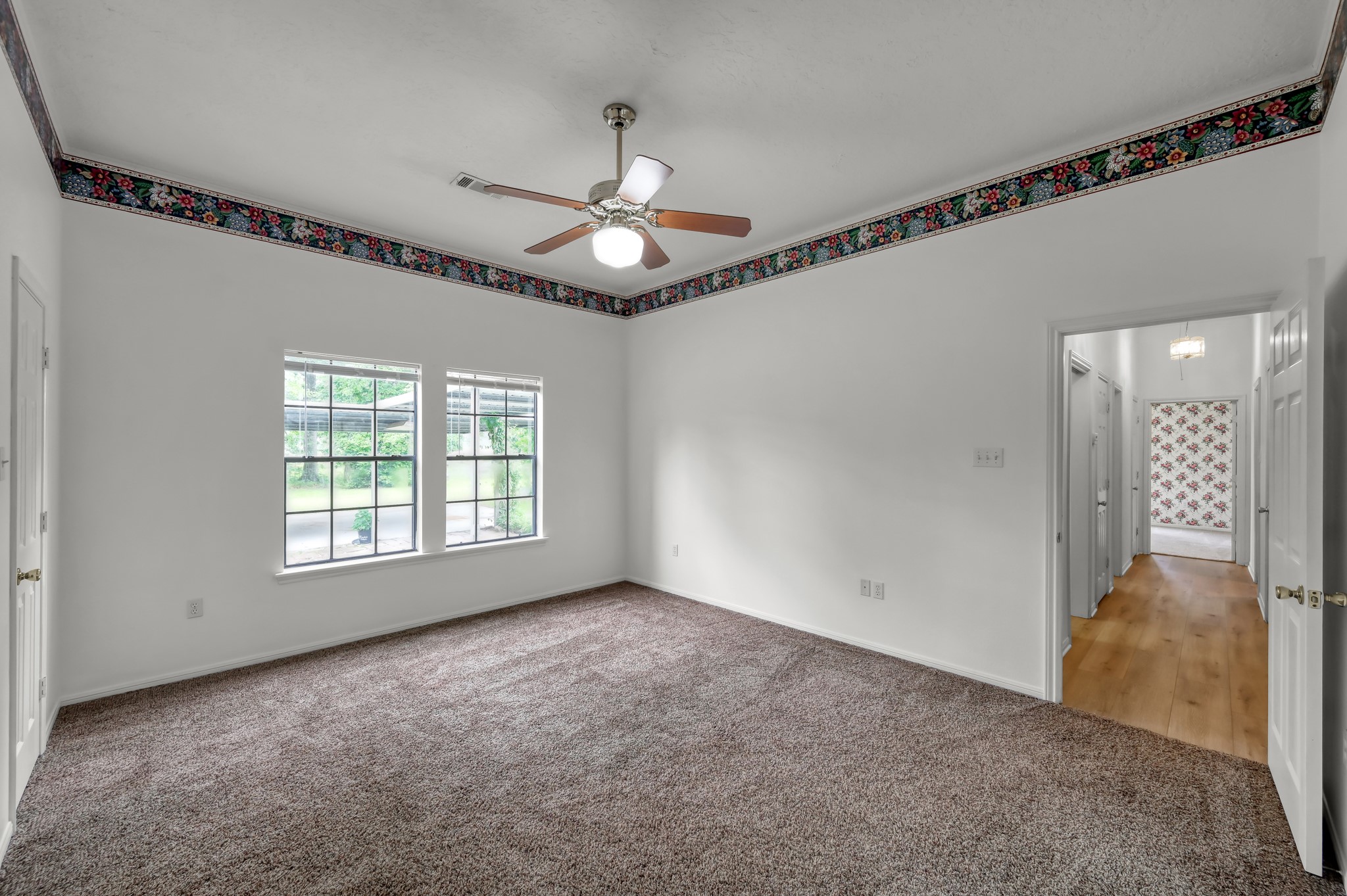 16892 Payne Road Conroe, TX 77302 - Photo 17 of 50 Primary Bedroom - The wall color is white with a wallpaper boarder.