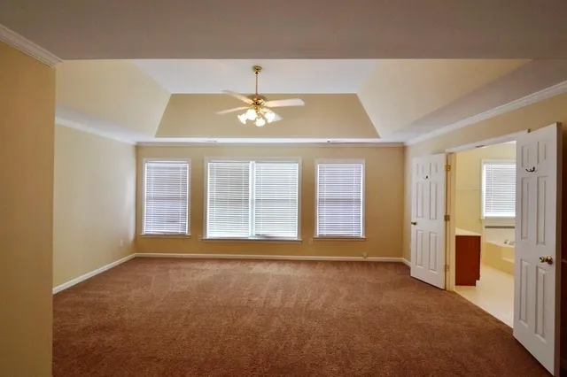 a view of an empty room with a chandelier fan
