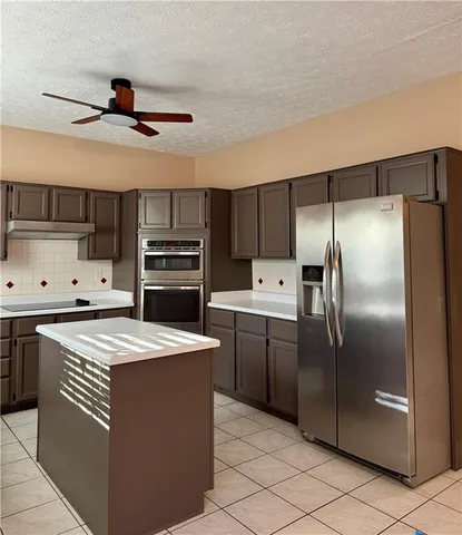 a kitchen with kitchen island white cabinets and stainless steel appliances