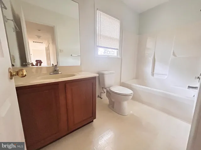a spacious bathroom with a sink toilet and a mirror